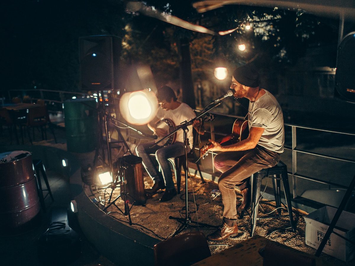 Duet muzyczny grający wieczorem w ogrodzie restauracji
